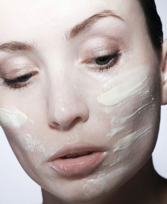 A Close-up Picture of a Woman Applying Cream on Her Face
