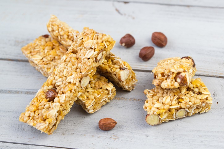 Homemade granola bars with roasted nuts, selective focus, wooden background
