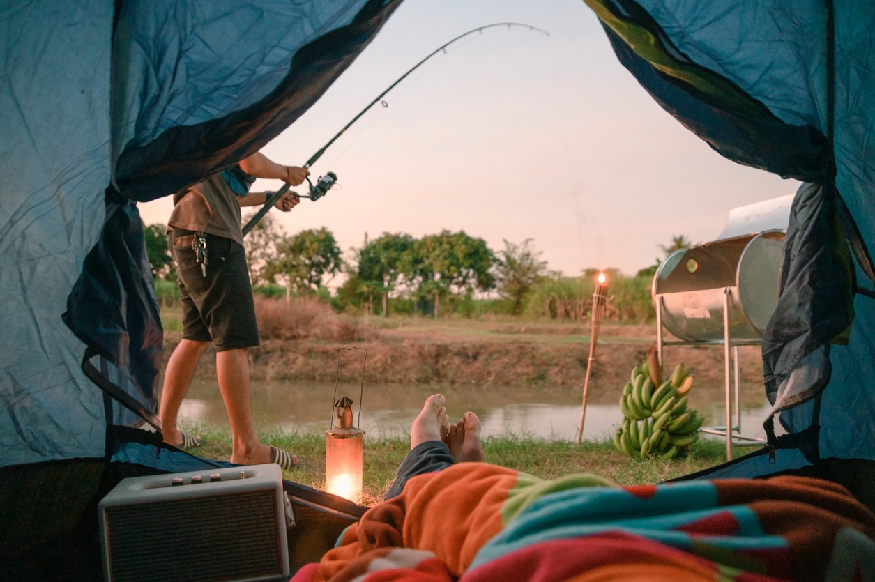 man fishing outside of a tent