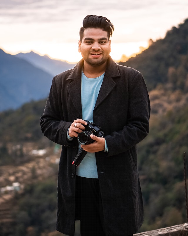 man wearing a blazer with camera on hand