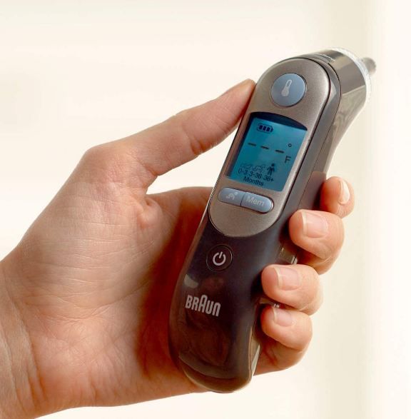 person holding a digital ear thermometer by Braun