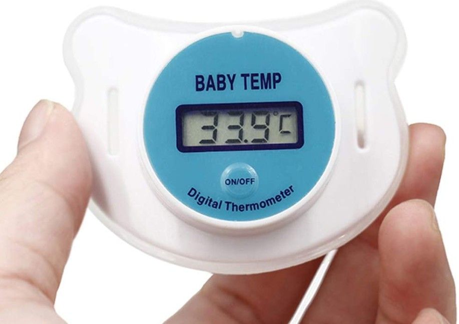 person holding a pacifier thermometer