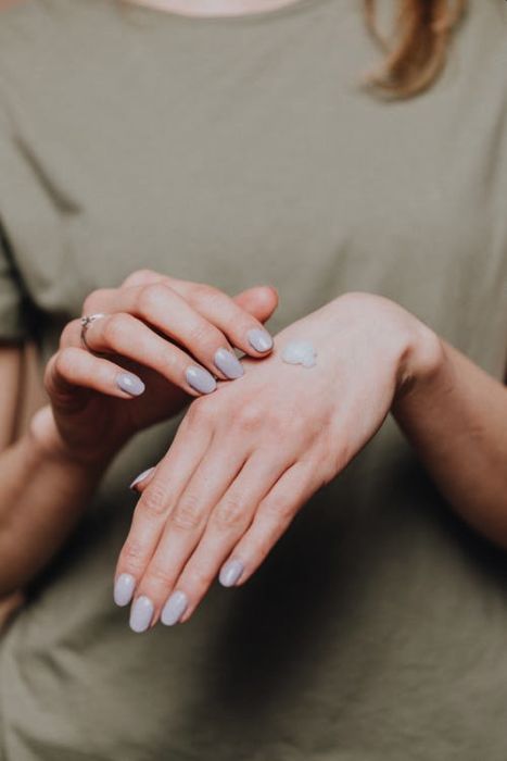 A Picture of Woman Applying Cream On her Hand