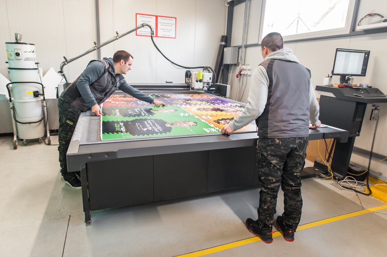 Two technicians works on CNC computer numerical control cutting machine