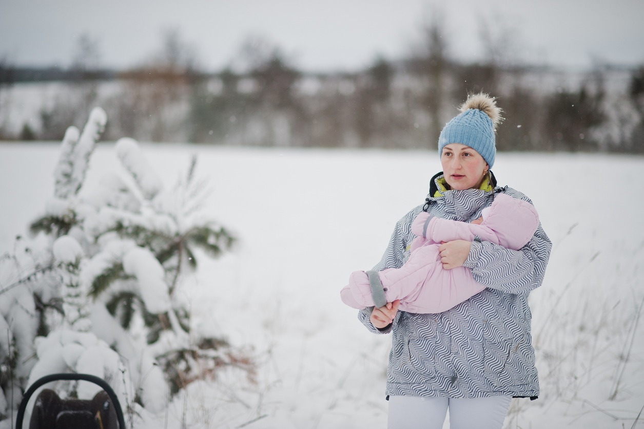 woman carrying a baby in snow