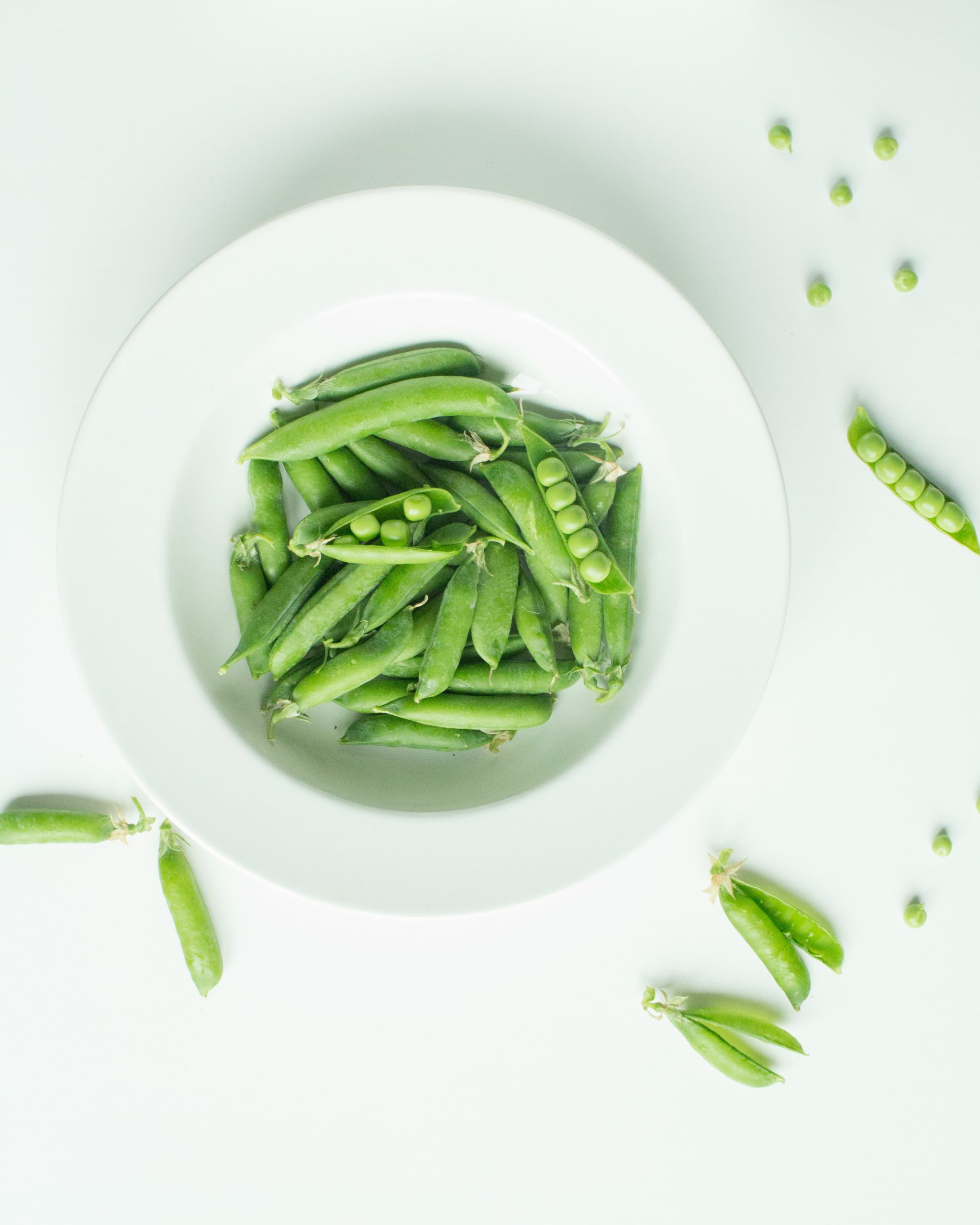 Green peas on white ceramic plate