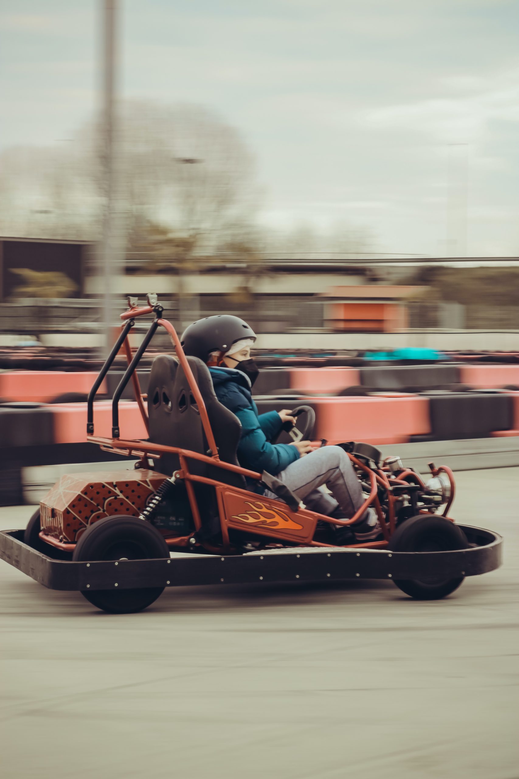 child in orange gas powered go-kart