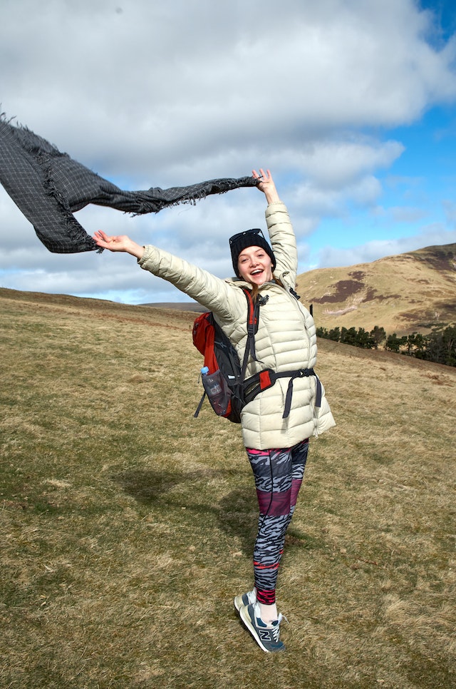 woman in insulated windbreaker with scarf flying