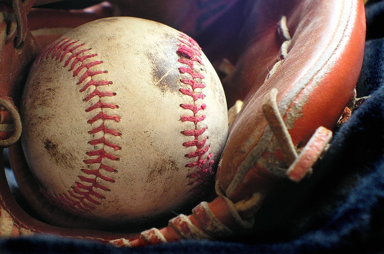 A dirty baseball inside a baseball glove
